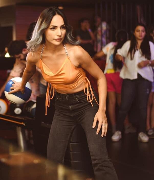 People bowling on glowing lanes with upbeat lighting