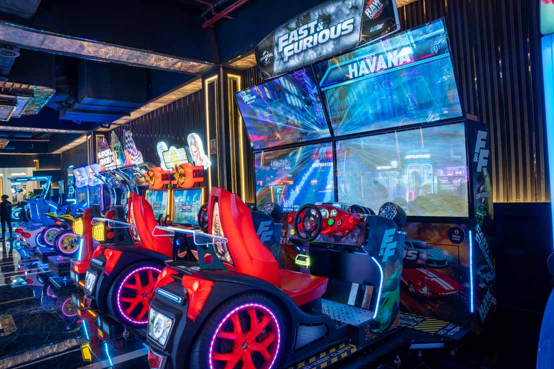 A vibrant image of people enjoying various arcade games and virtual reality experiences at The Game Palacio